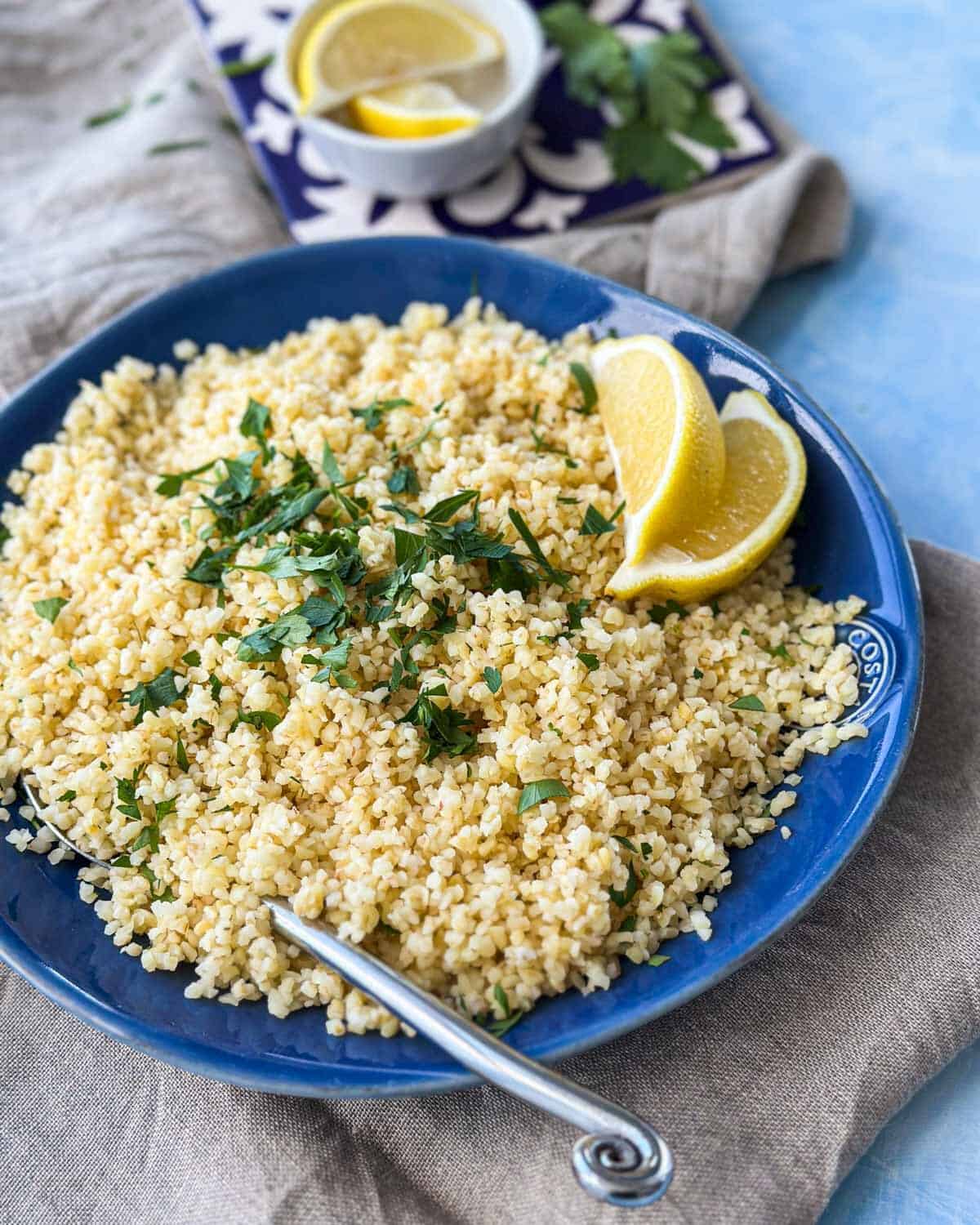 Bright and fresh bowl of cooked bulgur wheat with parsley and lemon, ideal for healthy meal prep.