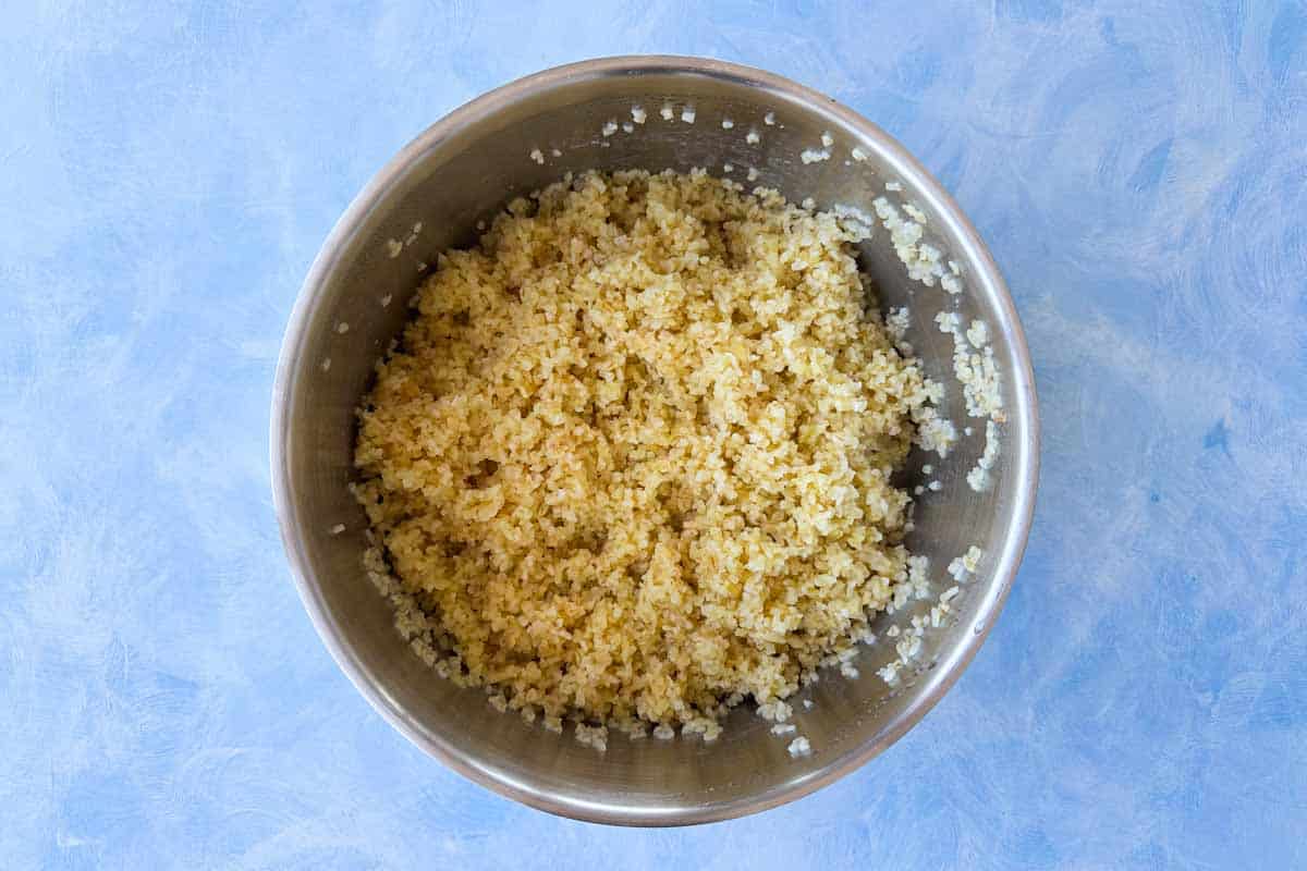 Cooked and fluffed bulgur wheat in a metal bowl, ready to serve.