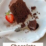 Single slice of chocolate ganache cake on a plate with a spoonful ready to eat.