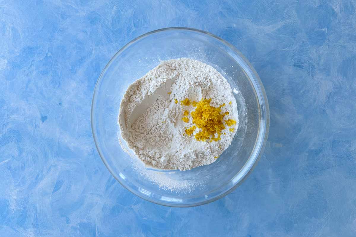Mixing bowl filled with flour and freshly grated lemon zest, showing the first step in preparing Greek yogurt pancake batter.