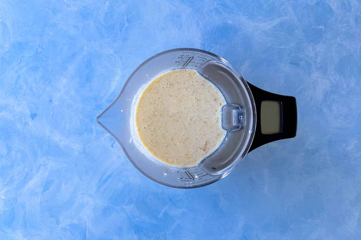 Smooth mixture of eggs, milk, Greek yogurt, and vanilla extract blended together in a jug, ready to combine with dry ingredients.