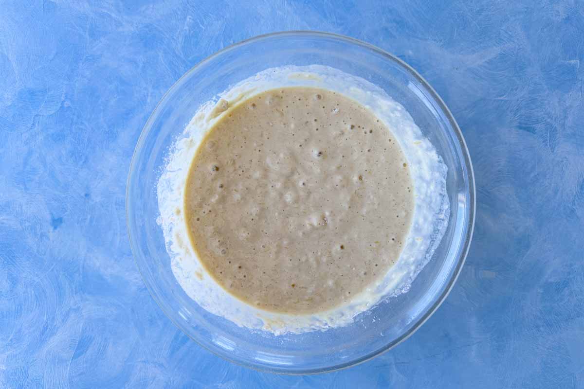 Thick, slightly bubbly pancake batter in a mixing bowl, indicating it is ready to cook.