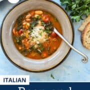 Overhead view of Italian Bean and Bacon Soup in a gray bowl with kale, white beans, tomatoes, and parmesan, served with fresh bread – cozy winter bean soup dinner idea.