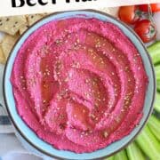 Vibrant homemade beet hummus with fresh vegetables for healthy snacking and party spreads.