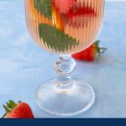 Strawberry and cucumber rosé sangria in a glass with fruit slices.