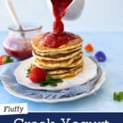 Healthy Greek yogurt pancakes topped with fresh strawberries and strawberry syrup.
