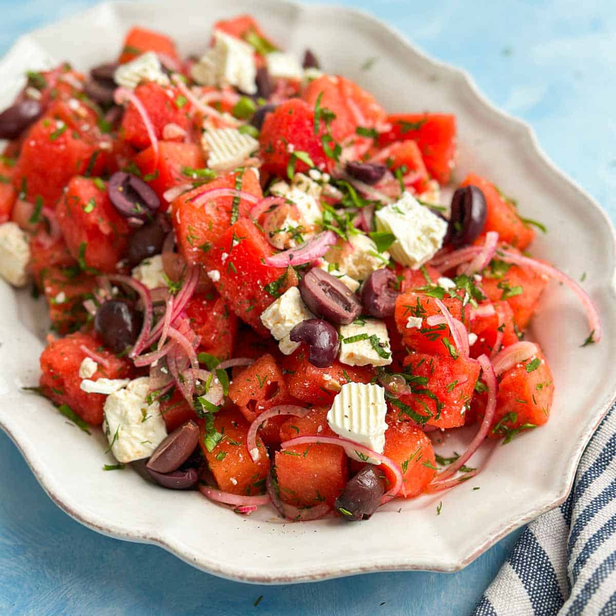 Close-up of watermelon and feta salad highlighting the contrast of sweet watermelon, creamy feta, and fresh herbs with a light dressing.