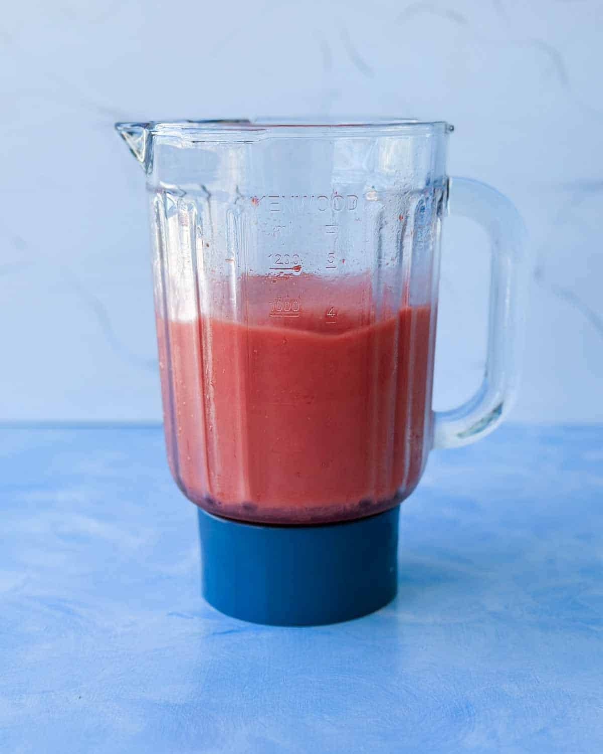 Blended watermelon smoothie in a glass blender jug with a smooth pink texture.