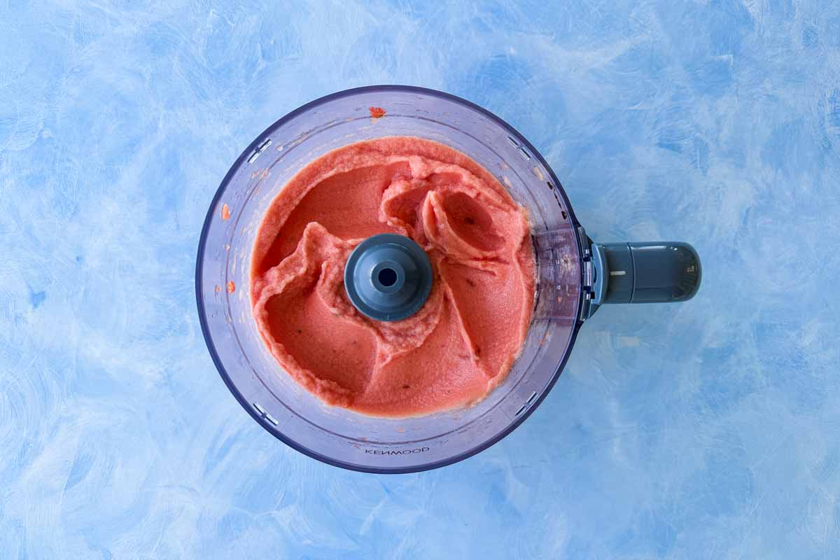 Smooth watermelon sorbet mixture blended in a food processor, showing the creamy texture before freezing.
