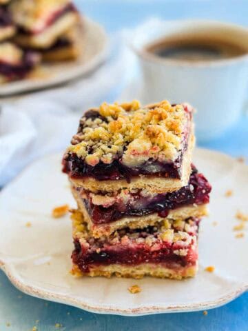 Close-up of homemade berry crumble bars layered with sweet-tart berries and a crisp buttery crumble topping.