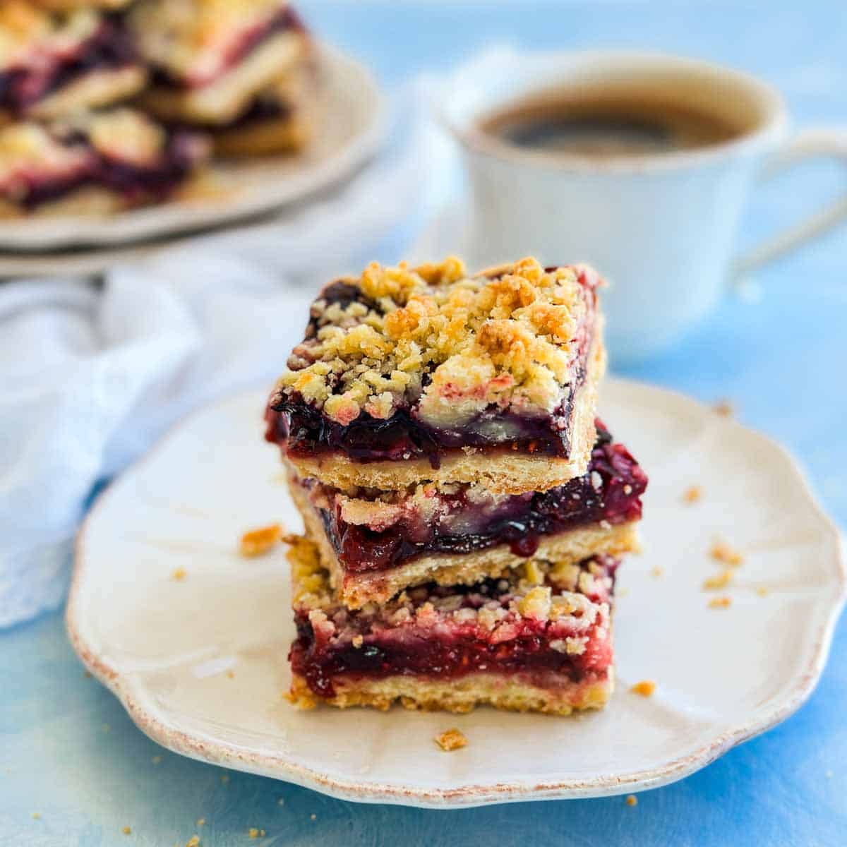 Close-up of homemade berry crumble bars layered with sweet-tart berries and a crisp buttery crumble topping.