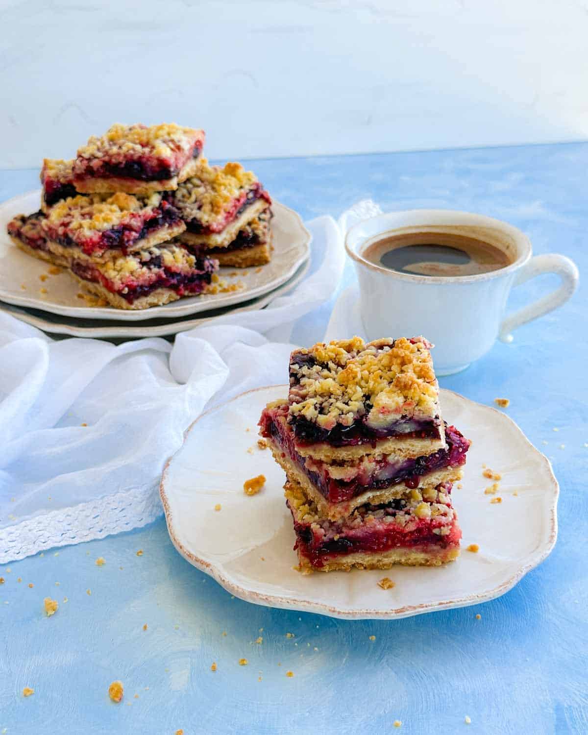 Berry crumble bars served with coffee, featuring layers of mixed berries, buttery shortbread, and crisp crumble topping.