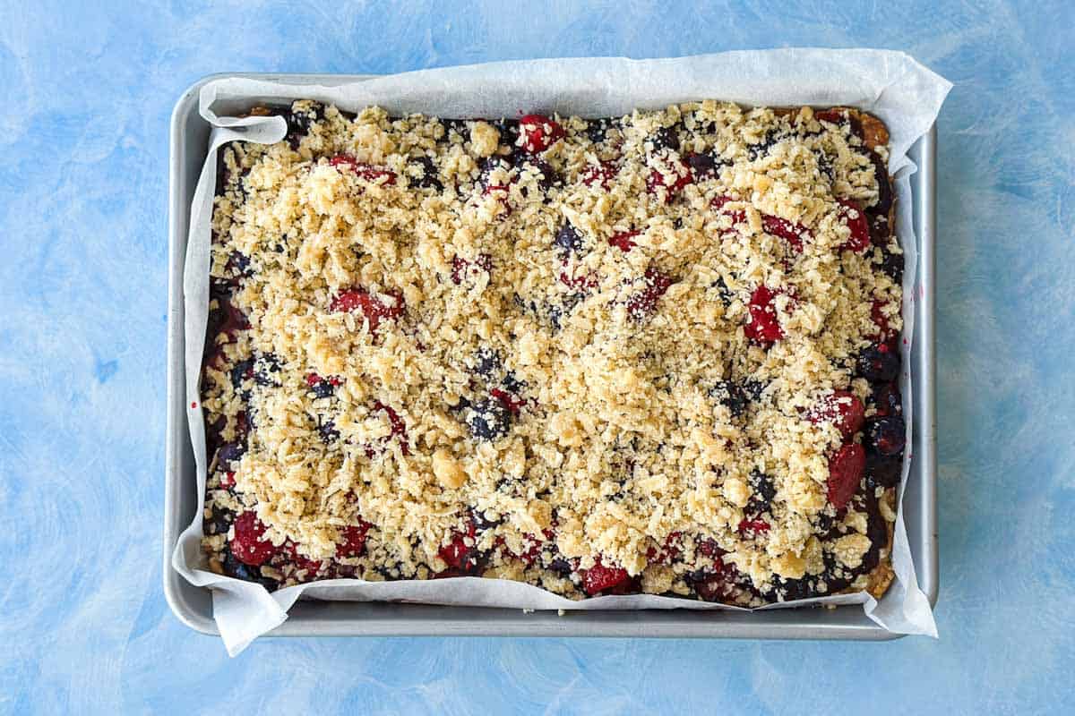 Reserved crumble topping sprinkled evenly over the berry filling before baking