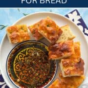 Delicious olive oil dip with herbs served with bread slices.