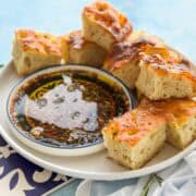 Close-up of golden focaccia bread served with olive oil bread dip made with balsamic vinegar, garlic, and herbs