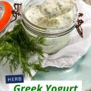 Creamy Greek yogurt dressing with herbs in a glass jar.