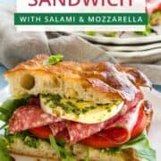 Delicious focaccia sandwich with salami, mozzarella, and fresh greens.