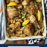 Baked chicken and potatoes with lemon wedges on a sheet pan.