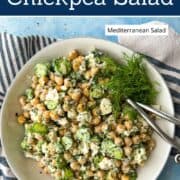 Fresh cucumber chickpea salad with herbs and feta cheese in a white bowl.