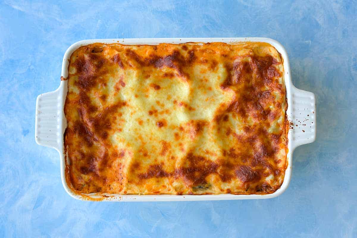 Overhead shot of baked Mediterranean vegetable lasagna with a golden, bubbly cheese topping.
