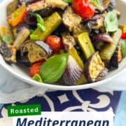 Colorful roasted Mediterranean vegetables with cherry tomatoes and basil.