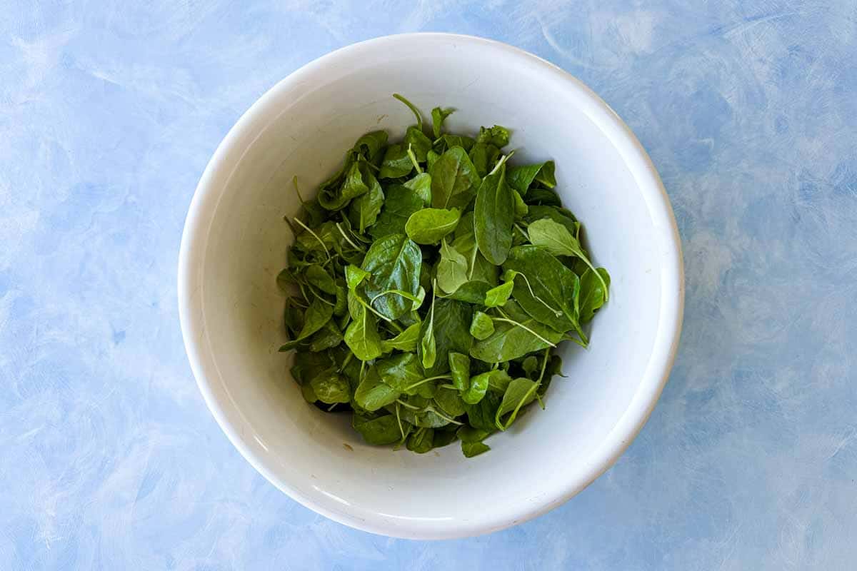 Bowl of fresh baby salad greens ready for assembling roasted butternut squash salad.