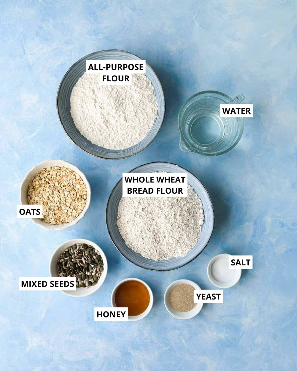 Labeled no-knead bread ingredients: all-purpose flour, water, whole wheat bread flour, oats, mixed seeds, honey, yeast, and salt.