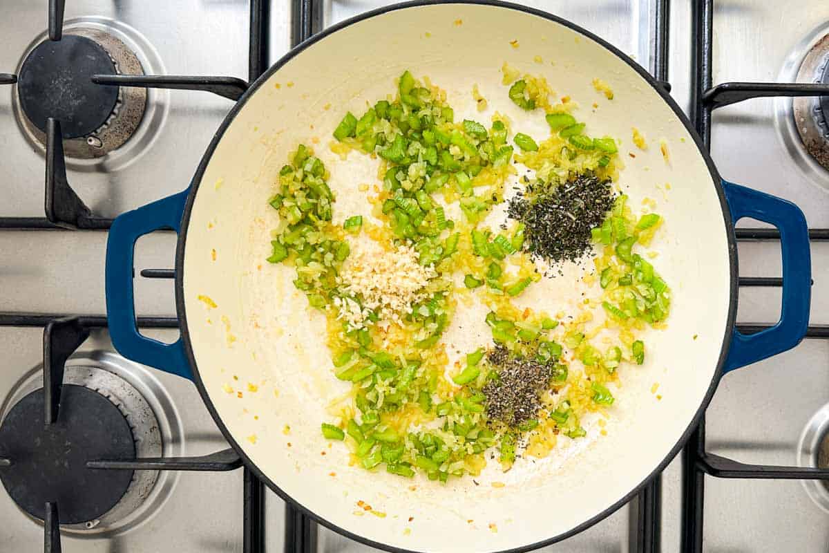 Minced garlic and dried herbs added to the sautéed onion and celery in the pot.