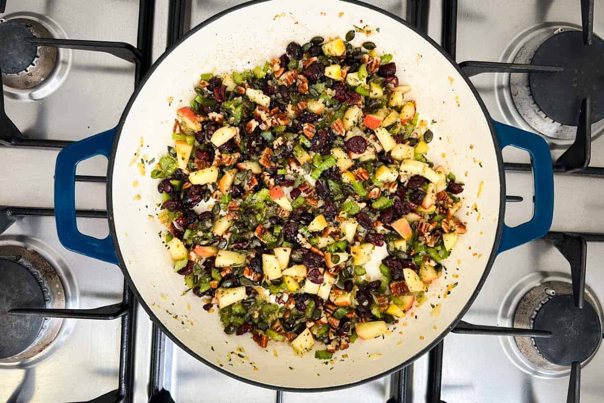 Apples, cranberries, pecans, and pumpkin seeds stirred together with the sautéed vegetables, before the rice is added.