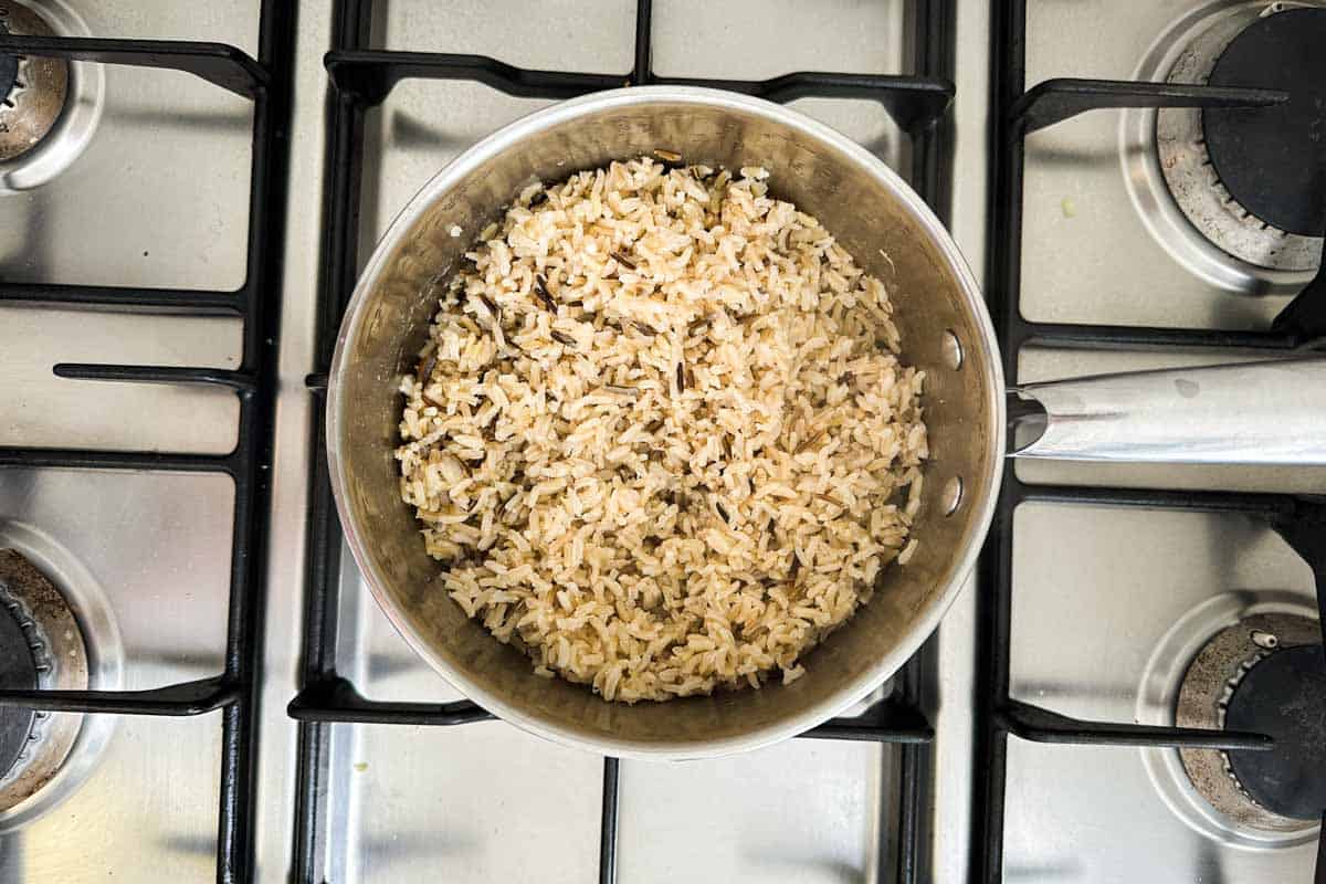 Cooked brown and wild rice blend in a separate pot on the stovetop.